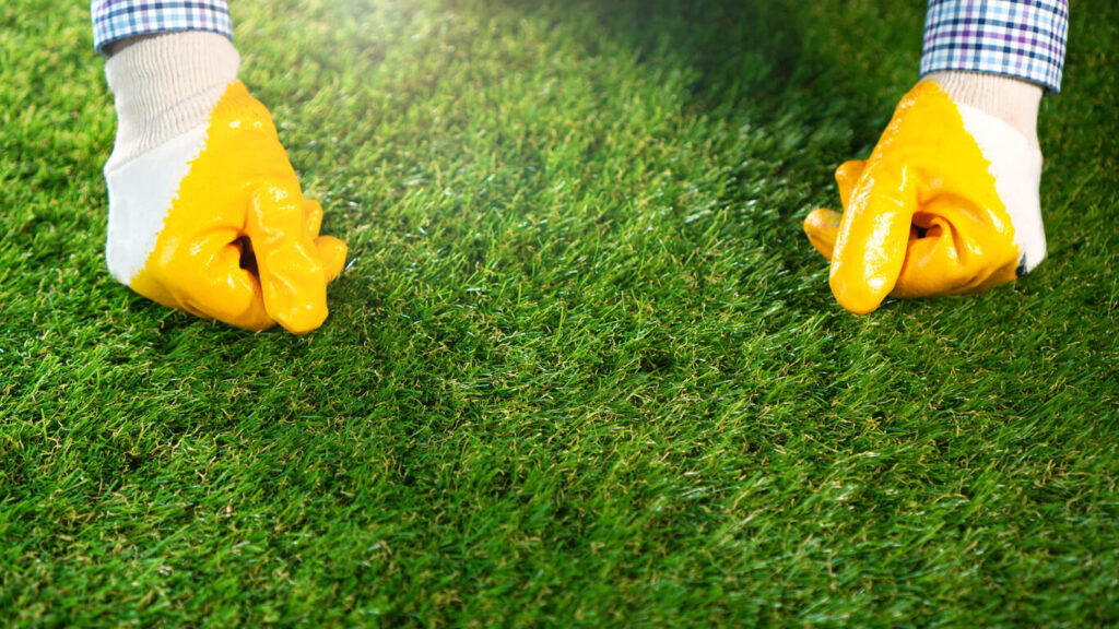 Worker hands on the synthetic grass